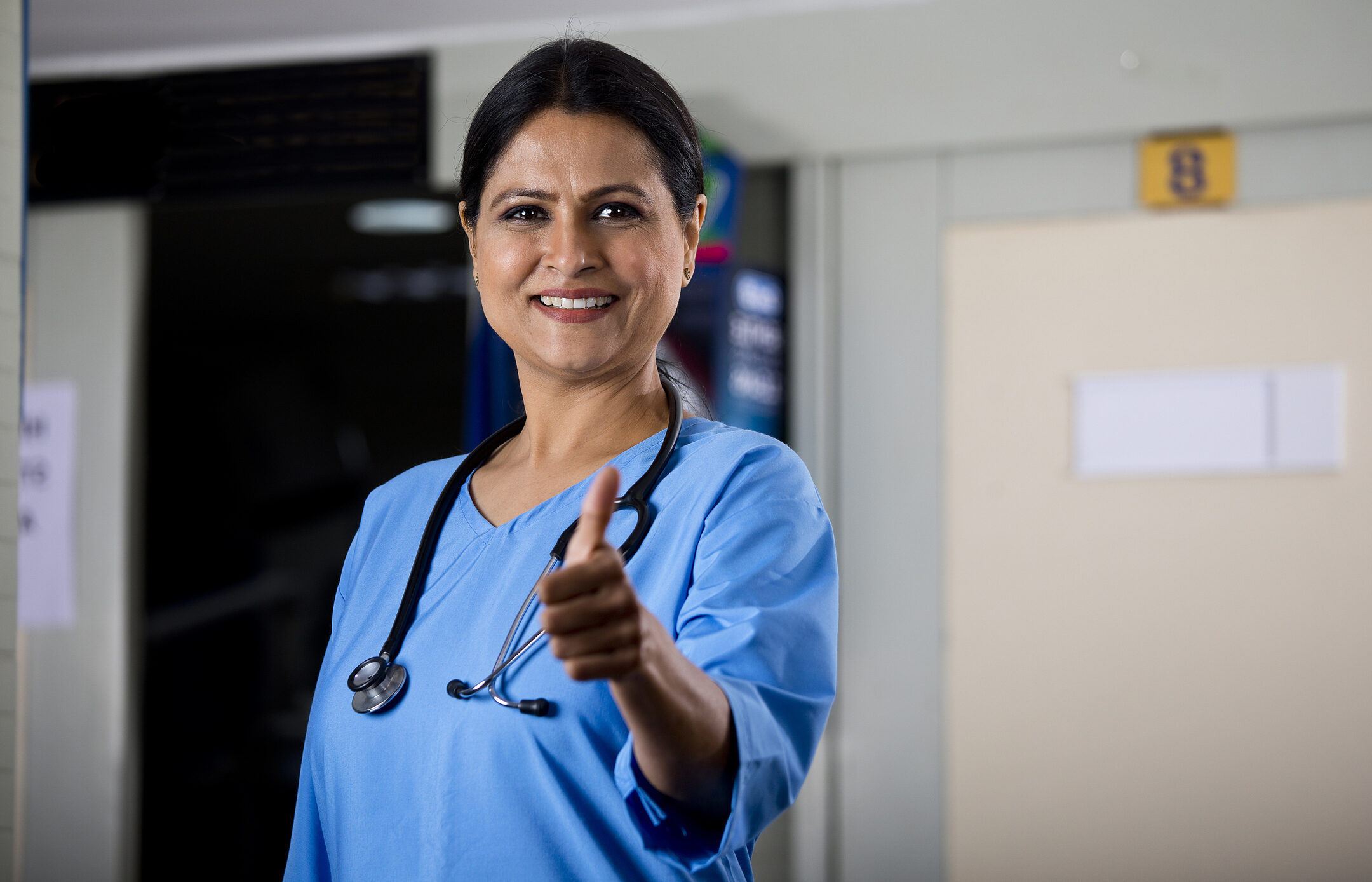 Confident female doctor giving thumbs up gesture